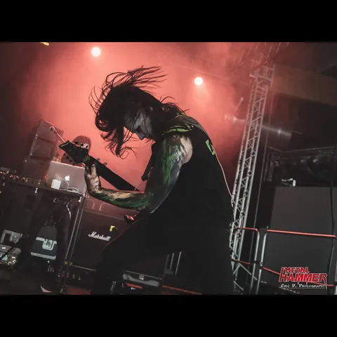 Guitarist headbanging under red stage light
