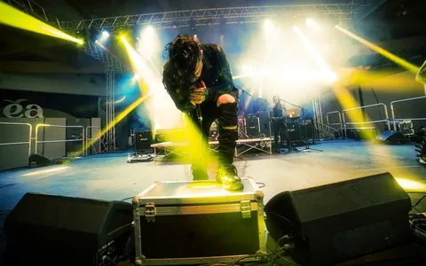 Singer on a festival stage cut by yellow beams