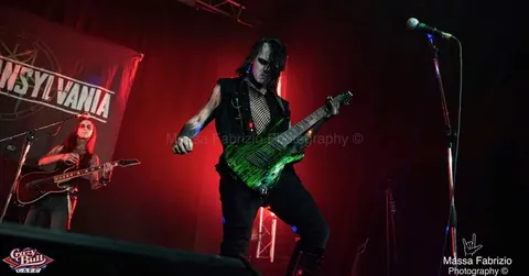 Guitarist with a green guitar in red light
