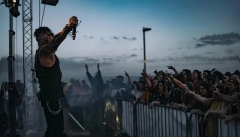 Singer facing an open air crowd at dusk