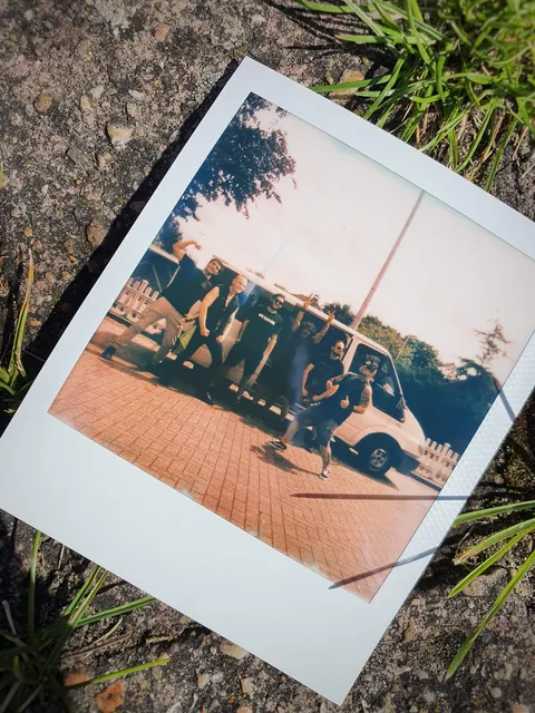 Polaroid of the band on the grass