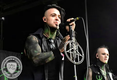 Singer at the sigil microphone stand with the guitarist behind